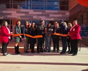 Students and dignitaries stand in front of the doors to new bullard-Havens Tech and cut the ribbon at the ribbon cutting ceremony