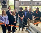 Representatives from CTECS, Shaffer Beacon Mechanical and Torrco, DCP Commissioner Bryan T. Cafferelli, DOL Deputy Commissioner Mark Polzella, and Tracy Ariel, OWS Director of Business Engagement cutting a ribbon with E.C. Goodwin HVAC students to celebrate an equipment donation.